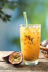 Tasty passion fruit drink and fresh fruits on wooden table
