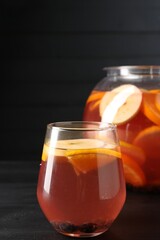 Fruity punch on black wooden table, closeup. Refreshing drink