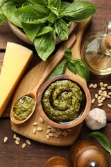 Fresh pesto sauce and ingredients on wooden table, flat lay