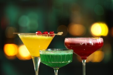 Glasses of alcoholic cocktails against blurred background, closeup
