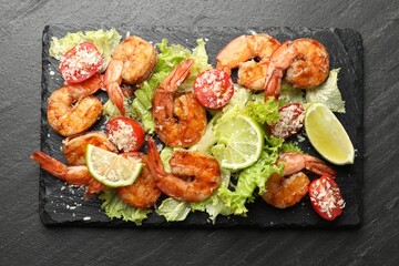 Tasty grilled shrimps with salad on black table, top view. Delicious seafood dish
