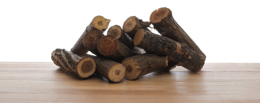 Pile of cut firewood on wooden table against white background