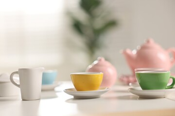 Tea set on white table indoors, closeup with space for text. Child's toy