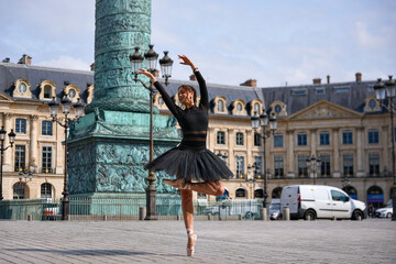 Elegant ballerina posing near column in city square © Moiseii Production