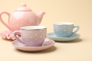 Beautiful ceramic tea set for children on beige background, closeup
