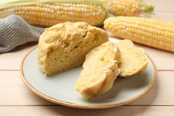 Freshly baked cornbread and cobs on wooden table, closeup