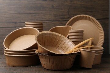 Set of disposable tableware on wooden table, closeup