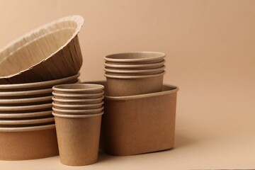 Set of disposable tableware on dark beige background, closeup. Space for text