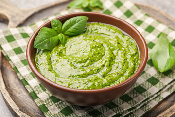 Fresh pesto sauce with basil leaves in bowl on table, closeup