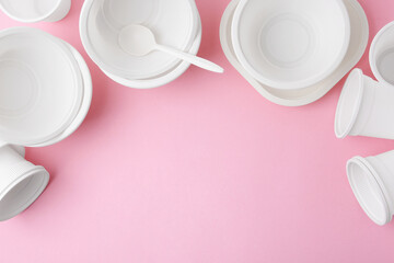 Set of disposable plastic tableware on pink background, flat lay. Space for text