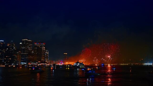 Beautiful celebration of the Independence Day in New York, USA. Fireworks flashing over the East River at night. Numerous boats stand watching the show.