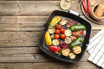 Pan with grilled vegetables and spices on wooden table, flat lay. Space for text