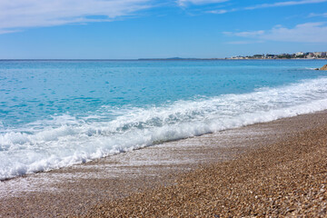 Beautiful view of wavy sea and pebbles on beach