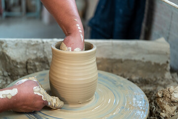 Potter creating a clay vessel with his own hands
