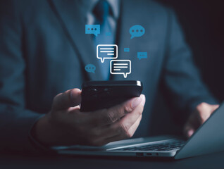 Businessman using smartphone with digital chat icons, symbolizing online communication, social media, messaging, mobile app, customer support for business networking, marketing, digital connection.