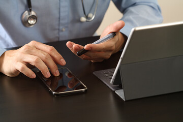Doctor using smartphone and tablet for telemedicine consultation