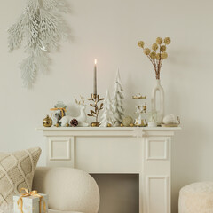Bright Christmas mantelpiece with reindeer figurine, golden candle holder, festive ornaments, and decorative trees in a modern interior.