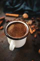 Mug of hot chocolate and spices on rustic background, cozy autumn scene