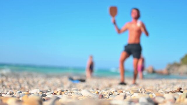 happy young man jumping on the beach, racket ball