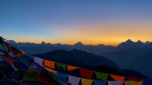 Colorful prayer flags draped against a majestic mountain range at sunrise
