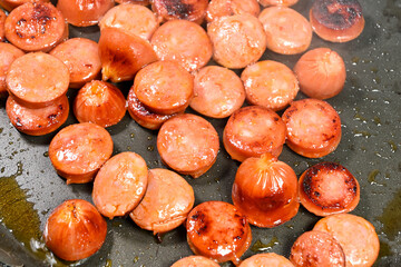 cut pepperoni sausages in frying pan