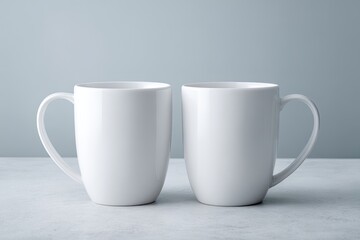 Obraz premium Two plain white mugs on a light gray surface