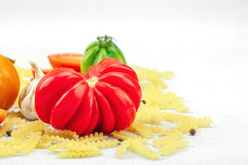 Raw mafalda corta pasta with assorted heirloom tomatoes, garlic, chili pepper, and spices