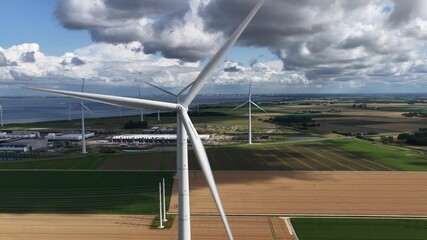 Wind turbine symbolizing renewable energy with large scale data center expansion in Eemshaven, Groningen, The Netherlands. AI, IT, internet infrastructure. - Powered by Adobe