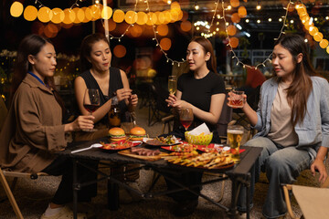Happy Friends Celebrating Together at Night, Young Asian Group of Friends Having Fun and Toasting Drinks Outdoors At Night, Enjoying a Celebration Concept.