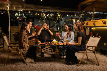 Happy Friends Celebrating Together at Night, Young Asian Group of Friends Having Fun and Toasting Drinks Outdoors At Night, Enjoying a Celebration Concept.