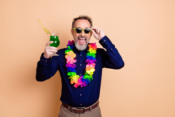 Cheerful Businessman Celebrating With a Colorful Lei and Refreshing Drink Against a Beige Background