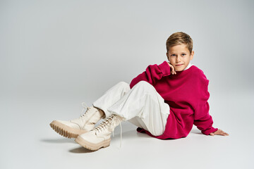 Cute preteen boy poses stylishly in trendy winter outfit against neutral backdrop
