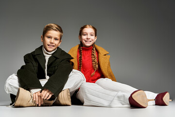 Cute preteen kids show off trendy winter fashion in studio setting