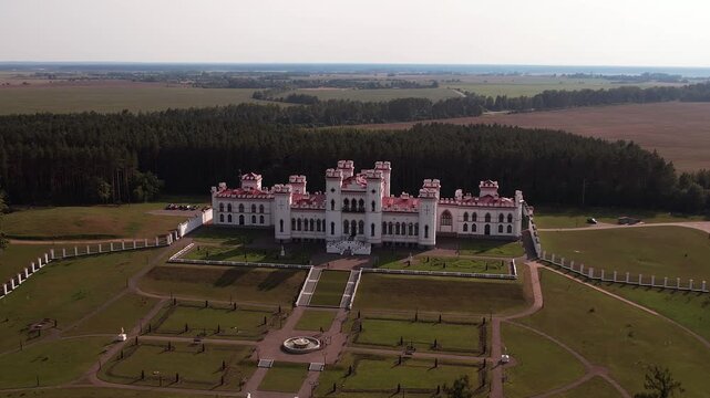Luxurious palace with park area with statues and fountain in town of Kossovo, Belarus. Bird's-eye view on unique neo-Gothic architectural monument with towers. Travel and tourism concept