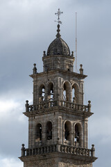 Obraz premium Historic Stone Bell Tower Against Cloudy Sky