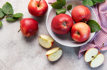 Red apples in bowl with slices on table