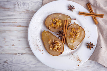 baked pear with honey, cheese, and nuts on a white plate.Baked pear with honey, cheese, and nuts on a white plate. The dish is presented for serving in a restaurant.