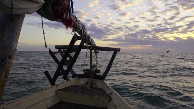 View from the front of a Traditional dhow sailing on the Indian Ocean at sunrise off the coast of Zanzibar.