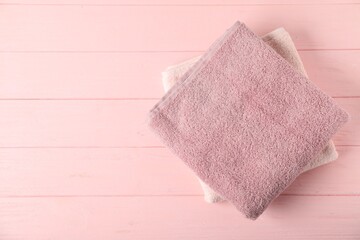 Fresh terry towels on pink wooden background, top view. Space for text