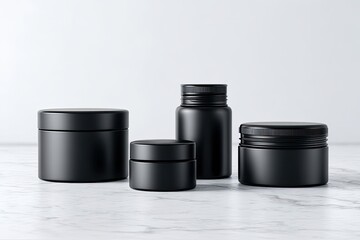 Four black cosmetic containers on marble