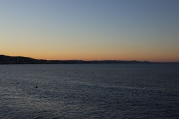 Beautiful seascape with city and mountains at sunset