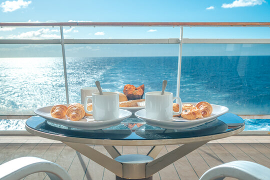 Table basse pour deux personnes avec un petit d&eacute;jeuner sur la terrasse d'une cabine balcon d'un navire de croisi&egrave;re avec vue sur la mer.	