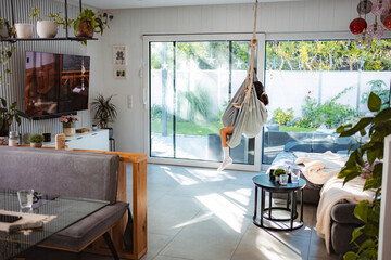 Woman relaxing in hanging chair at home living room