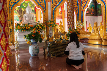 Thai Woman Praying Inside Ornate Buddhist Temple