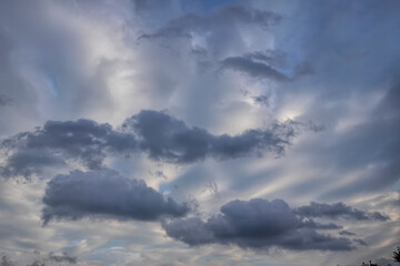 Dramatic clouds fill the sky, hinting at an approaching storm with their imposing presence and intricate formations.
