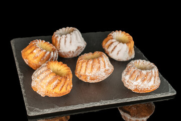 Sweet homemade cupcakes isolated on black background, close-up.
