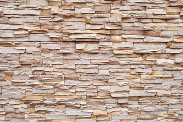 The texture of the wall is made of natural light stone, close-up. Beautiful brick wall background. Facing Stone, rock wall.