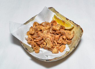 Crispy Fried Pork Rinds or Chicken Skin Crackers with Lemon in Plate side view of japanese food