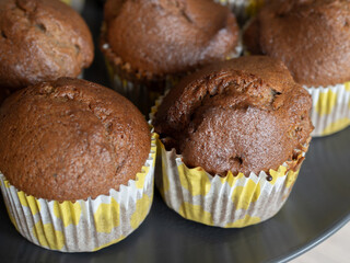Close up of chocolate brownie muffins in yellow dotted paper cups, homemade baked goods for breakfast or snack