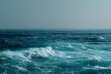 Calm Ocean Waves under Clear Blue Sky with Soft Horizon and Gentle Foam on Serene Water Surface